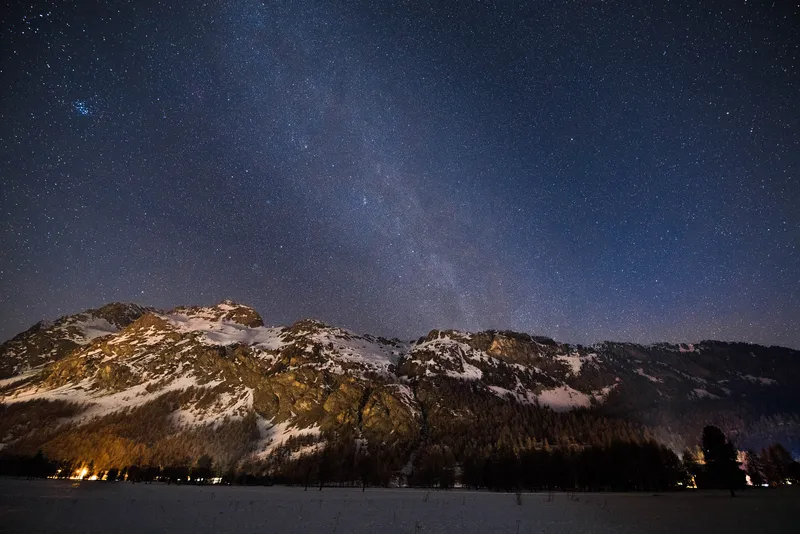 Sternenhimmel mit Milchstrasse über verschneiten Alpengipfeln